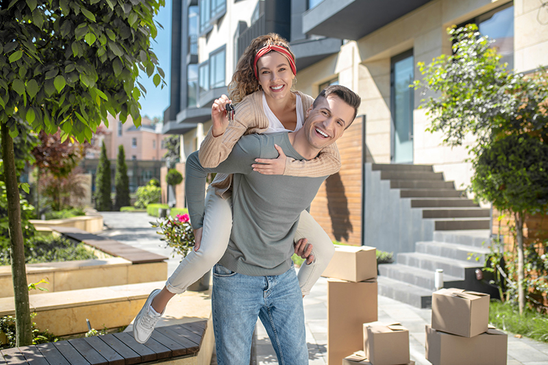 Happy couple with the keys to their new house after passing a home inspection